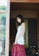 A woman standing in front of a wooden door.