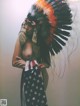 A woman wearing an indian headdress with an american flag on it.