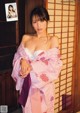 A woman in a pink and white kimono posing for a picture.