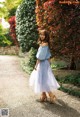 A woman in a blue top and a white tulle skirt.