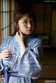 A woman in a blue and white kimono posing for a picture.