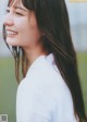 A woman with long brown hair smiles at the camera.