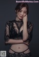 A woman in a black lingerie posing for a picture.