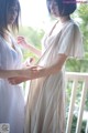 Two women standing next to each other on a balcony.